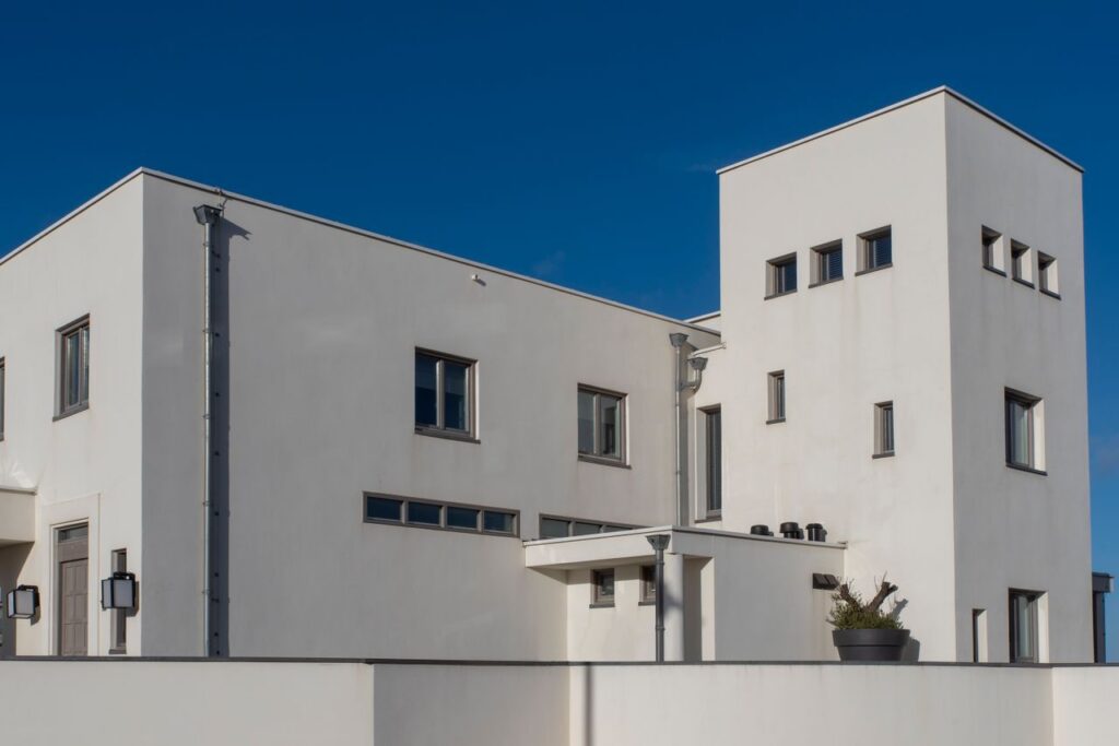 Elegant modern architecture of a white house under clear blue sky in Katwijk aan Zee, Netherlands.